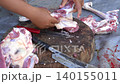 Butcher cuttingButcher cutting raw meat on a wooden chopping block	 raw meat on a wooden chopping block	 140155011