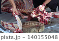 Butcher cuttinButcher cutting raw fresh meat on a wooden board on the ground	g raw fresh meat on a wooden board on the ground	 140155048