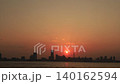 The silhouettes of the Minato Mirai buildings bathed in orange light, as seen from the Yokohama Bay Bridge, against the backdrop of the setting sun – a beautiful evening scene. 140162594
