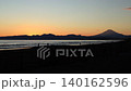 A time-lapse video of the sunset at Kugenuma Beach, showing surfers and people strolling, with the silhouette of Mt. Fuji in the background. 140162596