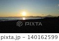 At Kugenuma Beach, people enjoying surfing on calm waves, with the silhouette of Mt. Fuji in the background – a beautiful evening scene. 140162599