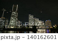 The illuminated skyscrapers of Yokohama's Minato Mirai district and their reflections on the waterfront create a stunning urban nightscape. 140162601