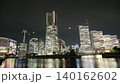 The illuminated skyscrapers of Yokohama's Minato Mirai district and their reflections on the waterfront create a stunning urban nightscape. 140162602