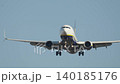 Passenger airplane approaches runway for landing at a busy airport on a clear day during peak travel hours 140185176