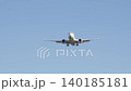 Passenger airplane approaches runway for landing at a busy airport under clear blue skies 140185181