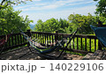 A woman resting in a hammock in a garden with fresh greenery. 140229106