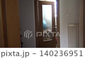 The door opens from the outside and a woman in jeans appears, who closes the door and goes into another room 140236951