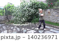A woman with her hair up does a body twist for joint health and mobility. This woman is taking care of her health 140236971