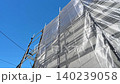 Exterior wall renovation with new siding and scaffolding netting. Exterior wall renovation with new siding and scaffolding netting. 140239058