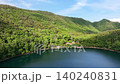 山間に広がる静かな湖と新緑が織りなす初夏のドローン映像素材 140240831