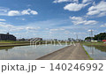 稻田和農路，水稻插秧剛結束，遠處可以看到城鎮景色和藍天。 140246992