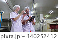 Two inspectors examining canned food and quality control in factory, food industry production line. 140252412