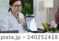 Asian nutritionist showing AI meal plan on tablet to senior patient. 140252418