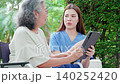Caregiver woman using digital tablet for senior patient consultation. 140252420