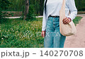 Walking in the park on a sunny day wearing a casual outfit with a bag and enjoying nature in the afternoon 140270708