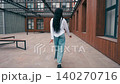 Walking through a modern outdoor space in a city center while wearing casual clothing 140270716