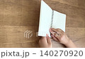 一隻孩子的手打開一本小小的活頁筆記本，從對角線角度拍攝；4K 無聲影片。 140270920