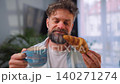 A man enjoying a fresh croissant and coffee for breakfast 140271274