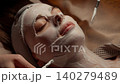 Relaxing spa facial treatment with soothing white cream mask applied by esthetician using brushes 140279489