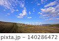 Dirt Road Trail Through Hills in Bulgarian Countryside at Sunset, Scenic Nature Landscape With Blue Sky and Rural Path, Mountain Meadow Panorama in Bulgaria, Outdoor Travel Destination, Peaceful 140286472