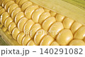 Close-up of partially husked yellow sweet corn ear with glossy kernels 140291082