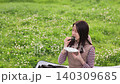 A woman eating rice balls at a picnic. 140309685