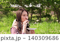 Close-up of a woman eating a rice ball at a picnic. 140309686