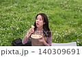 Dolly shot of a woman eating a sandwich outdoors 140309691