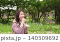 Side shot of a woman eating a sandwich outdoors 140309692