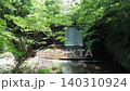 Cinematic drone flight slowly approaching a small forest waterfall surrounded by lush green woodland in Odawara, Kanagawa, Japan. 140310924
