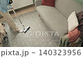Woman Vacuum Cleaning Carpet Floor At Home 140323956