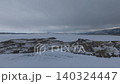 Aerial winter view of frozen Lake Baikal shoreline under dramatic cloudy sky 140324447