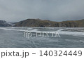 Winter ice patterns on Lake Baikal with mountain shoreline, Siberia aerial view 140324449
