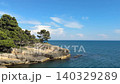 Mediterranean sea laps against the pine covered rocky shore. 140329289