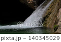 Slow Motion Waterfall Cascading Over Rugged Rock and Moss 140345029