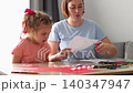Female parent helping child create handmade cards using paints and paper crafts. Early education and creativity growth concept 140347947