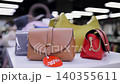 Assorted stylish handbags displayed on a sale in a modern retail store 140355611