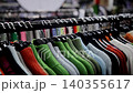 Clothing rack of colorful knit sweaters in a retail store. Woolen jumpers hanging on hangers 140355617
