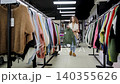 A woman chooses a warm sweater. Winter clothing store. A woman chooses warm clothes with interest. Lady shopaholic. Winter clothing store 140355626