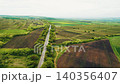 Aerial view of a car driving on a rural road 140356407