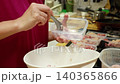 Woman hands scooping minced pork into plastic container for meal prep, storing raw meat portions in food box for freezing, home cooking kitchen organization routine, close up side view. VDO 4K. 140365866