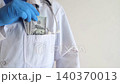 Close-up of doctor in white coat and blue gloves receiving or hiding cash. Concept of high medical salary, corruption in medicine, healthcare bribery, and expensive health insurance. Close-up of doctor in white coat and blue gloves receiving or hiding cash. Concept of high medical salary, corruption in medicine, healthcare bribery, and expensive health insurance. 140370013