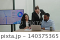 Portrait of Middle Eastern main manager guides renewable energy review with Latin and African American workers. Leader points at laptop and explains steps 140375365