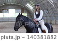 Woman riding horse in indoor equestrian arena 140381882