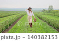 Young woman exploring fields wearing hat and boots 140382153