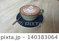 Delicious hot chocolate in cute ceramic cup with beautiful floral ornament on top of thick milk foam, perfect for cozy morning breakfast or relaxing coffee break inside a warm aesthetic cafe 140383064