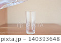 A glass of water poured from a pitcher 140393648