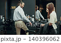 Female Barber Covering Client With Cape in Barbershop 140396062