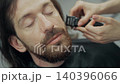 Female Barber Trimming Client Beard in Salon 140396066