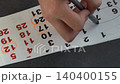 Hand Marking a Date on an Upside Down Calendar Page 140400155